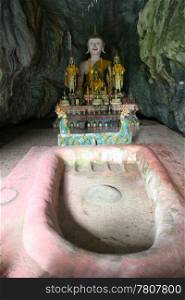 Golden Buddha and shrine in cave near Vang Vieng, Laos