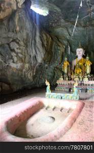 Golden Buddha and shrine in cave near Vang Vieng, Laos