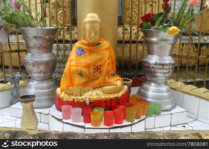 Golden Buddha and shrine near stupa in buddhist monastery, Yangon, Myanmar