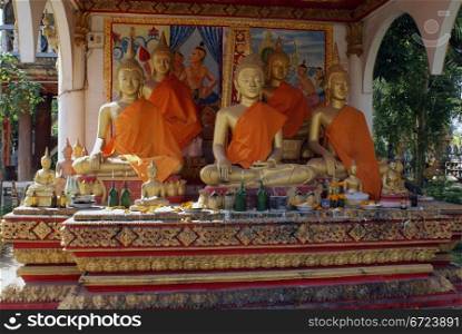 Golden buddhas in red robes, Laos