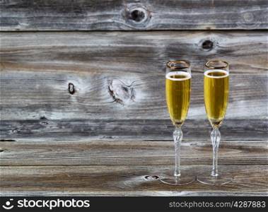 Golden champagne in elegant glasses on rustic wood