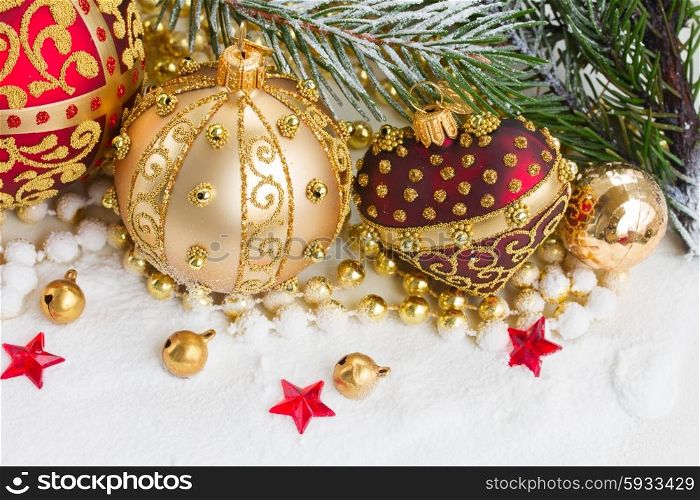 golden christmas ball and red heart with evegreen tree in snow . golden christmas bow and evegreen tree