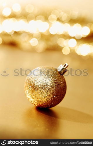 golden christmas ball on golden star bokeh background