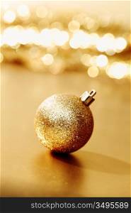 golden christmas ball on golden star bokeh background