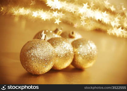 golden christmas ball on golden star bokeh background