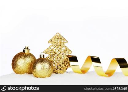 Golden Christmas decorations on snow close-up