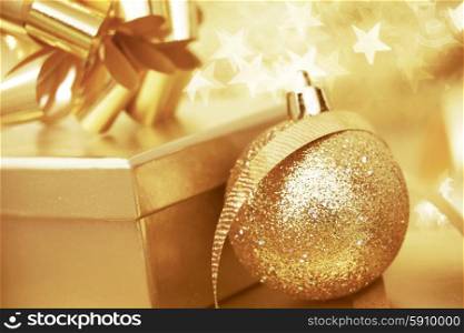 Golden christmas gift box and christmas ball on bokeh star background. Christmas gift and ball