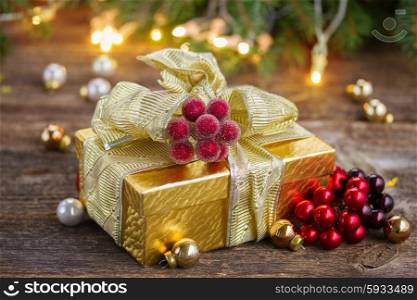 golden christmas gift box with lights in background on wooden table. christmas decorations with gift box