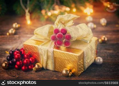 golden christmas gift box with lights in background on wooden table, retro toned