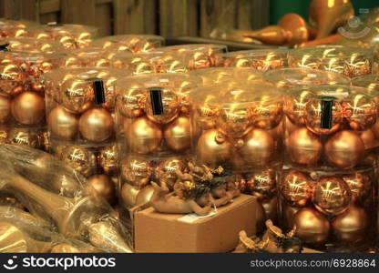 Golden Christmas ornaments in plastic containers in a christmas retail shop