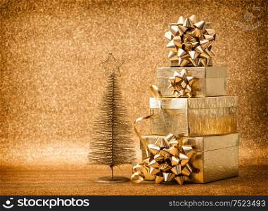 Golden christmas tree decoration with gift boxes. Holidays background. Vintage style toned picture