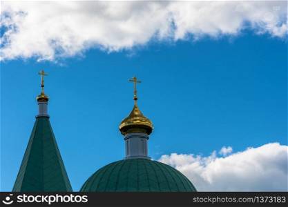 Golden Church domes on the background of beautiful cloudy sky.