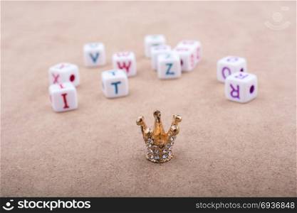 Golden color crown model in front of the letter cubes