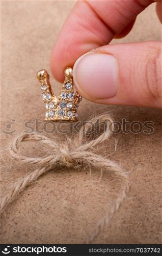 Golden color crown model with pearls on brown background