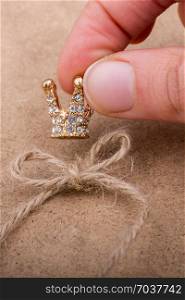 Golden color crown model with pearls on brown background