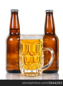 Golden colored beer in stein with two full bottles in background. Isolate on white with reflection.