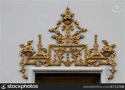 Golden decoration on the wall under door of temple, Bangkok, Thailand
