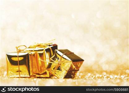 Golden decorative boxes with holiday gift on gold glitters background. Decorative gift boxes