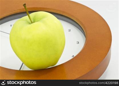 Golden, delicious apple placed on face of clock indicates that now is the time to face school, teacher, and education issues and policy changes in public, private, and charter schools;