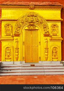 golden door on a red brick wall of a public Buddhist temple in China