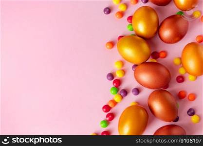 Golden Easter eggs and candies on a pink background. Happy spring holiday, place for text.. Golden Easter eggs and candies on a pink background. Happy spring holiday