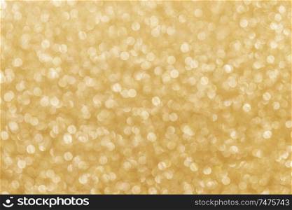 Golden festive glitter background with defocused lights. Festive glitter background