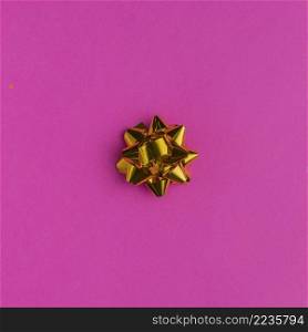 golden gift bow bright pink background