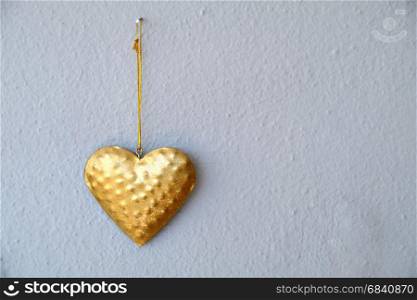 Golden heart over white wall