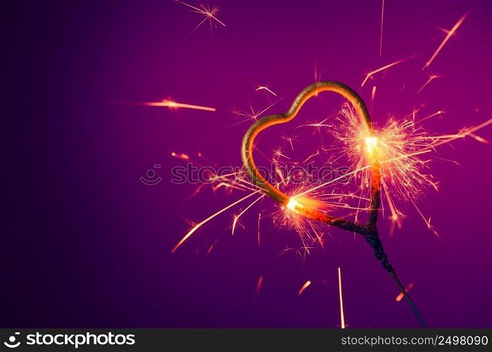 Golden heart shaped spark≤r burning bright with sparks