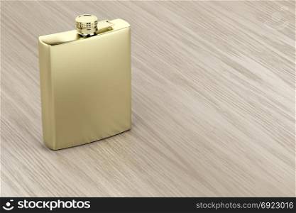 Golden hip flask on wooden table