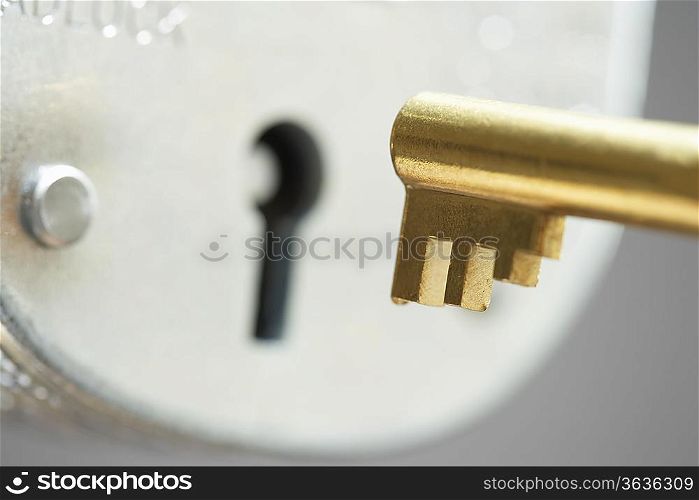 Golden key and padlock, close-up, selective focus