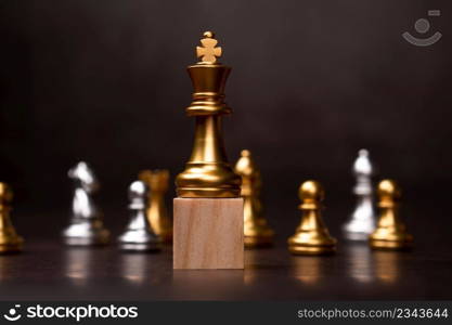 Golden king chess standing on a wooden stand. The concept of Leaders in good organizations must have a vision and can predict business trends and assess competitors