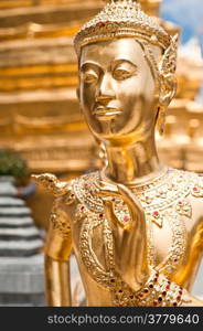 Golden Kinnari statue at Temple of Emerald Buddha (Wat Phra Kaew) in Grand Royal Palace. Half-bird, half-woman creature at south-east Asian Buddhist mythology. Bangkok, Thailand