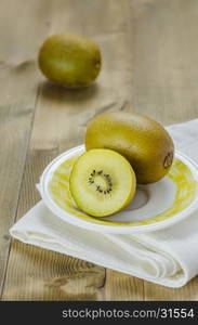 golden kiwi fruit and sliced . golden kiwi fruit and sliced on dish over wooden background