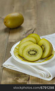 golden kiwi fruit and sliced . golden kiwi fruit and sliced on dish over wooden background