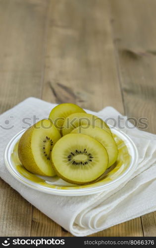 golden kiwi fruit and sliced . golden kiwi fruit and sliced on dish over wooden background