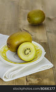 golden kiwi fruit and sliced . golden kiwi fruit and sliced on dish over wooden background