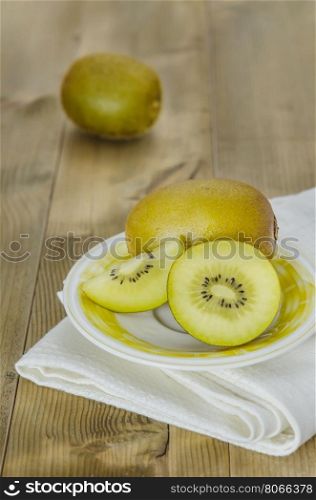 golden kiwi fruit and sliced . golden kiwi fruit and sliced on dish over wooden background