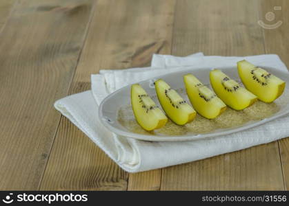 golden kiwi fruit and sliced . sliced of golden kiwi fruit on dish over wooden background