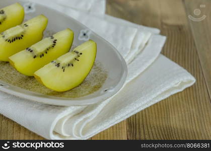 golden kiwi fruit and sliced . sliced of golden kiwi fruit on dish over wooden background