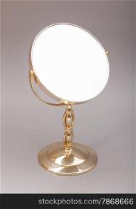 Golden mirror isolated on gray background
