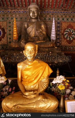 Golden monk in wat Phra Kaew Don Tao in Lampang, Thailand
