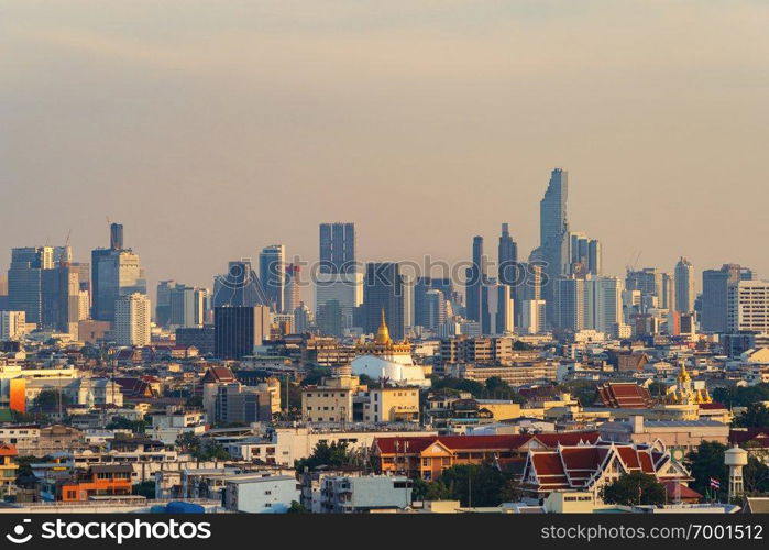 Golden Mount, Loha Prasat Wat Ratchanatda, and skyscraper buildings at sunset in Bangkok City, Thailand. Buddhist temples.