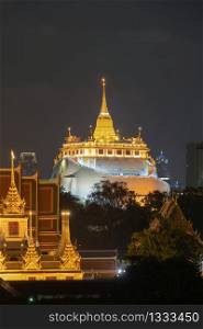 Golden Mountain pagoda, a buddhist temple or Wat Saket at night in Bangkok Downtown skyline, urban city, Thailand. Thai traditional architecture landscape background.