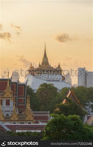 Golden Mountain pagoda, a buddhist temple or Wat Saket at sunset in Bangkok Downtown skyline, urban city, Thailand. Thai traditional architecture landscape background.