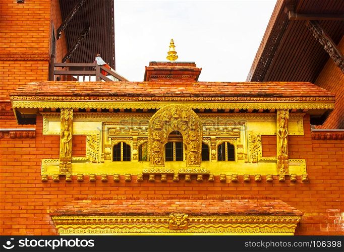 golden pattern on a red brick wall of a public Buddhist temple in China