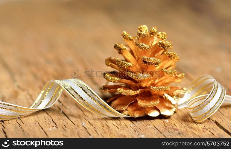 Golden pine cone on old wooden background