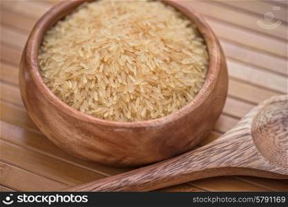 golden rice. golden rice on wooden plate on wooden background