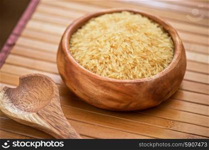 golden rice. golden rice on wooden plate on wooden background