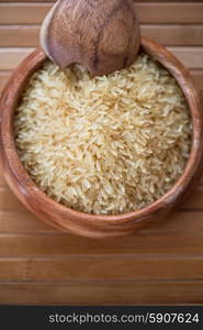 golden rice. golden rice on wooden plate on wooden background